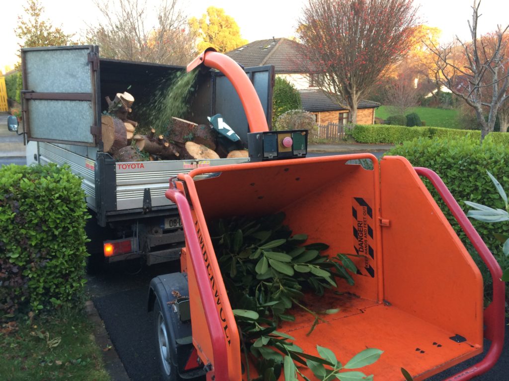 Wood chipper or shredder converting pile of branches into wood chips in Bray, Co. Wicklow